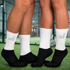Mann und Frau mit Padel Tennis Socken auf einem Padel Tennis Platz. Sportsocken für Padel Tennis spielen.