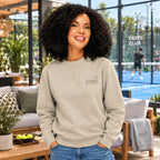 Sweatshirt für Padel Tennis und Tennis Spieler, kuscheliger Pullover vor und nach dem Training. Frau steht nach dem Training im Padel Tennis Outfit vor einem Padel Club Platz.